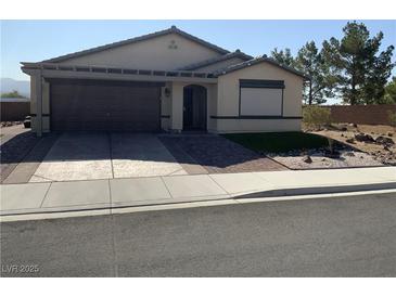 Single-story home featuring a two-car garage, desert landscaping, and a neutral color palette at 5363 S Juneau St, Pahrump, NV 89061