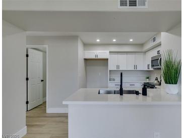 Modern kitchen featuring white cabinets, quartz countertops, and a stainless steel microwave at 555 E Silverado Ranch Blvd # 2129, Las Vegas, NV 89183