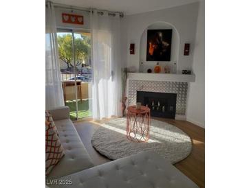 Bright living room with fireplace, modern decor, and sliding doors to outdoor balcony at 7885 W Flamingo Rd # 2129, Las Vegas, NV 89147
