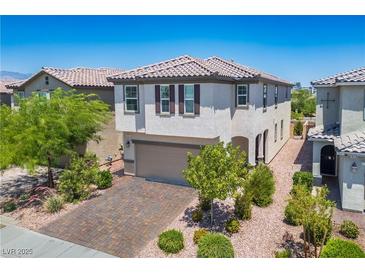 Charming two-story home featuring a well-manicured front yard with a brick driveway at 9136 Cocowoods Pl, Las Vegas, NV 89148