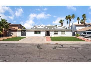 Charming single-story home featuring a well-maintained lawn, updated exterior, and a spacious driveway at 2990 Carnelian St, Las Vegas, NV 89121