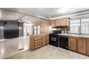 Well-lit kitchen featuring wood cabinets, granite counters, a black appliance package, and designer backsplash at 3471 Cape Cod Dr, Las Vegas, NV 89122