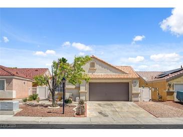Charming single story home featuring a two car garage and low maintenance desert landscaping at 406 River Glider Ave, North Las Vegas, NV 89084