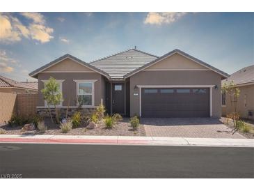 Charming single-story home featuring a two-car garage, desert landscaping, and a welcoming front porch at 817 Cottonwood Hill Pl, Henderson, NV 89011