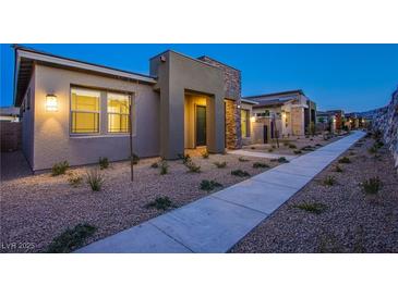 Charming single-story home featuring neutral color palette, stone accents, desert landscaping, and a welcoming entryway at 909 Allister Fields Ln, Las Vegas, NV 89138