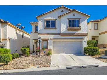 Charming two-story home with a well-manicured front yard, attached garage and desert landscaping at 10413 Rising Harbor Ave, Las Vegas, NV 89129