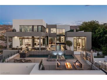 Stunning modern home featuring a multi-level pool, spa, outdoor kitchen, and lounge areas with beautiful mountain views at 1491 Reims Dr, Henderson, NV 89012