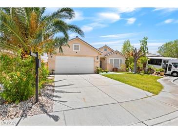 Inviting single-story home with a well-manicured lawn, complemented by a spacious driveway and desert landscaping at 2707 Wild Breeze Ct, North Las Vegas, NV 89031