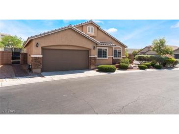 Inviting single-story home featuring a two-car garage, stone accents and well-manicured landscaping at 4508 Dragon Fly Creek Ave, North Las Vegas, NV 89031