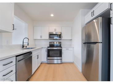 Modern kitchen featuring stainless steel appliances, white cabinetry, and light countertops at 50 Armstrong Cir, Henderson, NV 89015