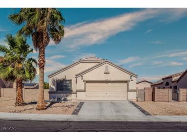Charming single-story home featuring a two-car garage, desert landscaping, and mature palm trees at 5028 Crying Heart St, North Las Vegas, NV 89031