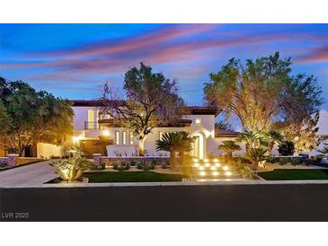 Elegant two-story home featuring a beautifully landscaped yard, illuminated stairs, and a warm, inviting ambiance at 11906 Port Labelle Dr, Las Vegas, NV 89141