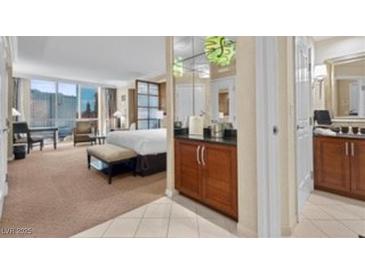 Bright bedroom featuring a luxurious bed, workspace and a convenient wet bar area at 135 E Harmon Ave # 407, Las Vegas, NV 89109