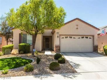 Inviting single-story home featuring a well-manicured lawn, desert landscaping, and an attached two-car garage at 2473 Luminous Stars St, Henderson, NV 89044