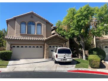 Two-story home with a tan stucco finish, tile roof, three-car garage and a well-manicured front lawn at 259 Rockwell Springs Ct, Henderson, NV 89012
