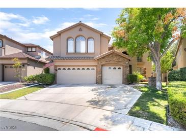 Charming two-story home featuring a three-car garage, stone accents, and a well-manicured front lawn at 259 Rockwell Springs Ct, Henderson, NV 89012