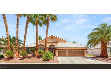 Charming single-story home with mature palm trees, a tile roof, and a three-car garage at 286 Bowsprit Ct, Las Vegas, NV 89183