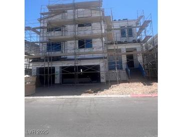 Unfinished two-story home featuring a spacious garage, stairs to the front door, and construction scaffolding at 10236 Rosemont Hills St, Las Vegas, NV 89141
