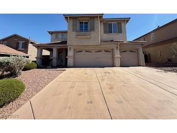 Two-story home featuring a large driveway, three-car garage and neutral toned stucco exterior at 1177 Twinkling Meadows Dr, Henderson, NV 89012