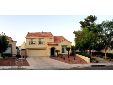 Inviting two-story home showcasing desert landscaping, a red tile roof, and a two-car garage at 2140 Desert Peak Rd, Las Vegas, NV 89134