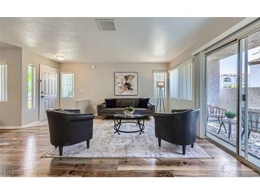 Bright living room features modern furnishings, wood floors, and a sliding glass door to the outdoor patio at 3125 N Buffalo Dr # 1133, Las Vegas, NV 89128
