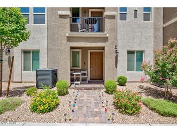 Charming townhome with a small front yard featuring decorative landscaping and a second-story balcony at 668 Tiarella Ln, Henderson, NV 89015