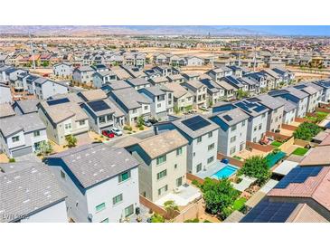 View of a community featuring neatly lined homes, some equipped with solar panels and private pools, against a desert landscape at 10434 Rose Palisade St, Las Vegas, NV 89141