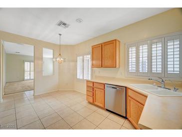 Bright kitchen features tile flooring, wooden cabinets, stainless steel appliances, and natural light at 3025 Seaford Peak Dr, Henderson, NV 89052