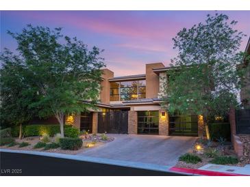 Striking home showcases modern design, desert landscaping, and driveway leading to the garage at 38 Moonfire Dr, Las Vegas, NV 89135