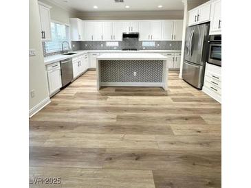 Spacious kitchen features an island, stainless steel appliances, and white cabinets at 776 Tillis Pl, Las Vegas, NV 89138