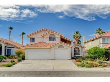 Two-story home featuring a well-manicured lawn, desert landscaping, and three-car garage at 8416 Dry Cliff Cir, Las Vegas, NV 89128