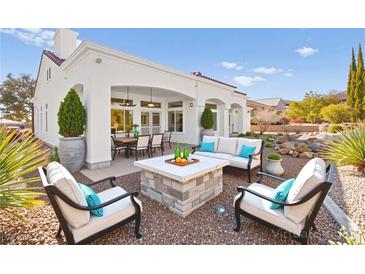 This backyard patio features a stone fire pit, comfortable seating, and a covered outdoor dining area at 10920 Grand Haven Ave, Las Vegas, NV 89134