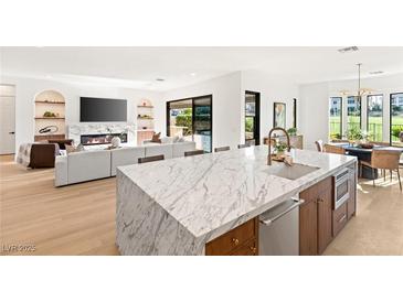 Open-concept kitchen featuring a marble island, stainless steel appliances, and seamless flow into the living area at 1987 Orchard Mist St, Las Vegas, NV 89135