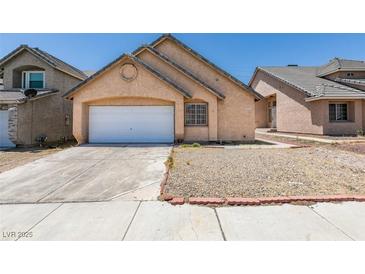 View of the home's front exterior featuring an attached garage and low maintenance landscaping at 3127 Kennewick Dr, Las Vegas, NV 89121