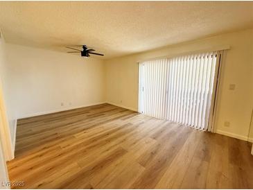 Bright room featuring wood-look floors, a ceiling fan, and sliding glass doors leading to outdoor space at 3270 Liahona Way, Las Vegas, NV 89121