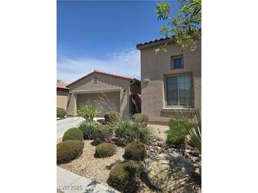 Charming stucco home with well-maintained desert landscaping and a tile roof at 4408 Oasis Plains Ave, North Las Vegas, NV 89085