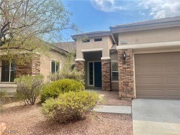 Inviting single-story home featuring desert landscaping and a charming, covered entryway at 9421 Wisdom Valley Ave, Las Vegas, NV 89149