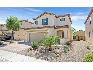 Two-story home featuring a two-car garage, desert landscaping, and a charming front porch at 953 Via Del Tramonto St, Henderson, NV 89011