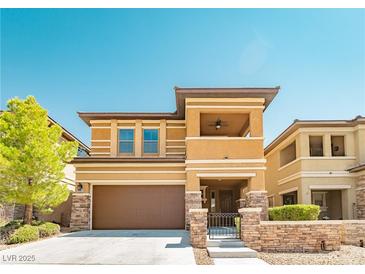 Inviting two-story home with a brown garage door and stone accents, surrounded by a well-maintained lawn at 10404 Mystic Pine Rd, Las Vegas, NV 89135
