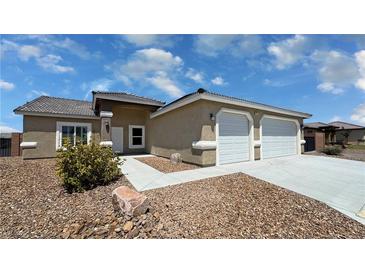 Charming single-story home featuring a desert-landscaped front yard and two-car garage at 210 Magnolia Blvd, Pahrump, NV 89048