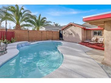 Inviting backyard pool features a waterfall, lounge chairs, and privacy fence perfect for relaxation at 5005 Harmony Ave, Las Vegas, NV 89107