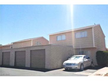 Two-story townhouse with three garages and a car parked out front on a sunny day at 5155 Gray Ln, Las Vegas, NV 89119