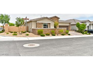 Charming single story home with stone accents, neat landscaping, and an attached two car garage at 10972 Dixie Johnson Ave, Las Vegas, NV 89166
