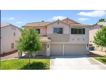 Two-story home featuring a three-car garage, tile roof, and lush lawn, perfect for Gathering living at 1371 Cumulus Ct, Henderson, NV 89014