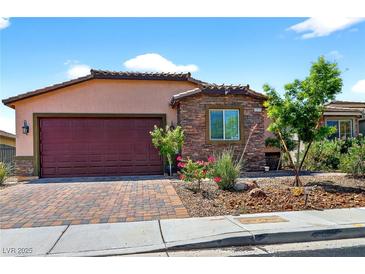 Charming single-story home featuring stone accents, a red garage door, and well-maintained landscaping at 2079 Port Royal Dr, Laughlin, NV 89029