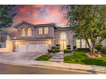 Stunning two-story home with a three-car garage, lush landscaping, and inviting entrance at 2496 Ram Crossing Way, Henderson, NV 89074