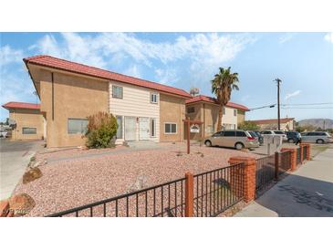 Two-story tan building with a red tile roof, desert landscaping, black fencing and ample parking at 2915 Cedar Ave # 11C, Las Vegas, NV 89101
