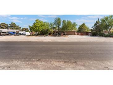 Single story home with desert landscaping and a long driveway on a sunny day at 4905 Ricky Rd, Las Vegas, NV 89130