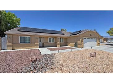 Charming single-story home featuring solar panels, rock landscaping, and an attached two-car garage at 4910 Marywood Ct, Pahrump, NV 89061