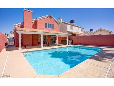 A refreshing pool provides a welcome escape in the backyard of this inviting coral-colored home at 1428 Daybreak Dr, Las Vegas, NV 89108